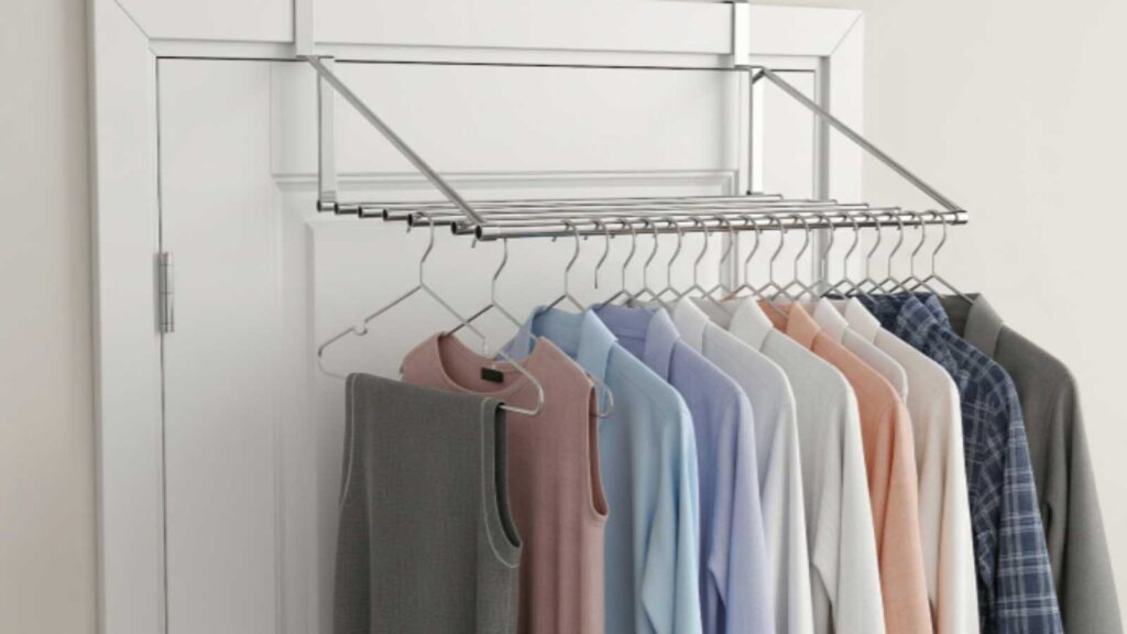 Space-saving over-the-door clothes drying rack with multiple shirts hung to air-dry indoors. 